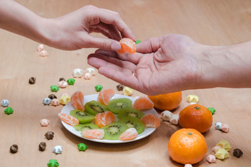 female hand giving mandarin to man