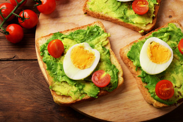 Fototapeta na wymiar Toasts with avocado, сherry tomatoes and eggs