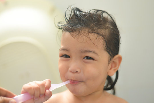 dental hygiene. happy Asian little girl or kid brushing her teeth by toothbrush in the bathroom. Healthcare concept.