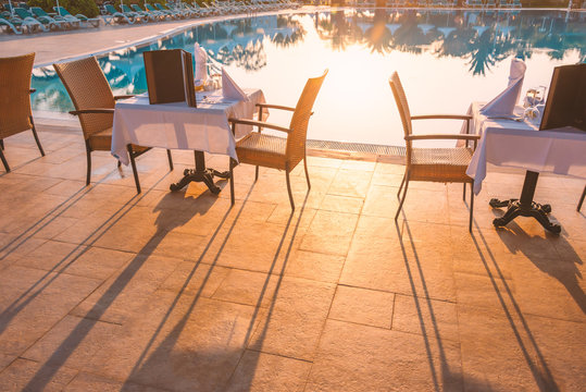 Chairs And Table Near Pool At Hotel Restaurant