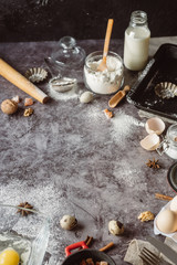 Healthy baking ingredients. Spoon with flour, dishes, eggs, butter salt and rolling pin on a grey background.Bakery background frame. Top view, copy space.