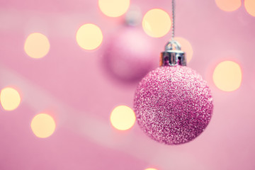 Fototapeta premium Picture of two Christmas pink balls on pink background with spots.