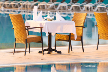 Chairs and table near pool at hotel restaurant