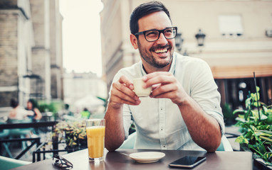 Young man sitting in the cafe and drinking coffee. Lifestyle concept
