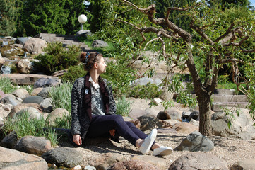 young woman sitting on a rock