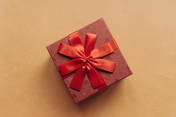 Red box with a bow with a gift on a yellow background.