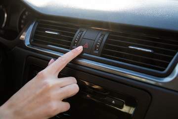 The girl's hand presses the button of the alarm system and the car