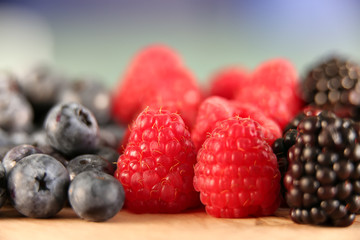 Mixed berries on a wooden background with selected focus. Raspberries Blackberries and Blueberries. Healthy Living and Nutritious Food concept.Close up
