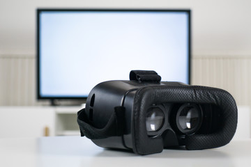 VR headset in front of blurred TV background - VR Goggles - Gaming