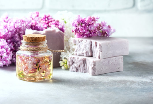 Handmade soap, Glass jar with fragrant oil and lilac flowers for spa and aromatherapy.
