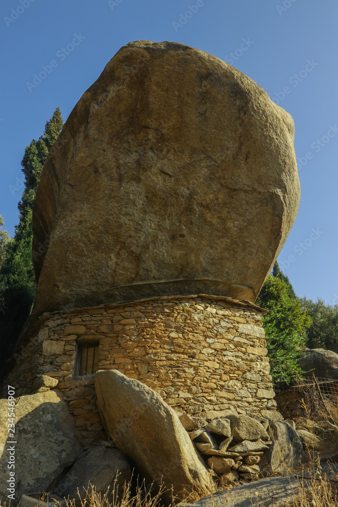 Sticker ancient ikarian stone house with overhanging rock shelter on Ikaria Island, North Aegean Sea, Greece