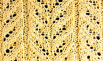 Yellow knitted textured background with a pattern closeup