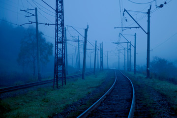Fototapeta na wymiar Railway in fog on station, outdoor landscape