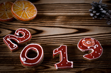 Christmas card on wood background gingerbread red numbers 2019 with slices of orange