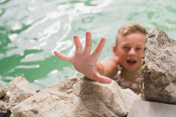A boy ask something to help him to get out from the lake
