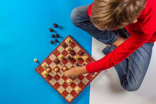 Kid Sitting Near Chessboard And Play Chess Game