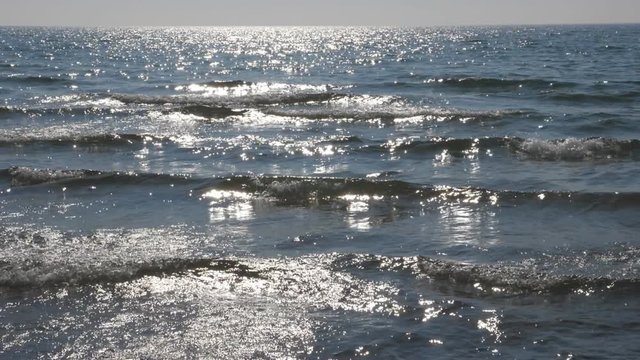 Slow motion sunlit waves coming into shore. Lake Ontario, Canada.