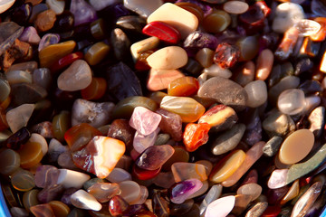 Background. Texture of a group of colorful natural stones for women's jewelery. Cropped shot, close-up, place for text. Concept of beauty and hobby.
