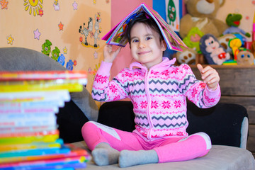 Cute girl on the background of her toys with a book