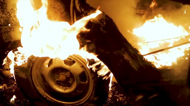 A wheel burns in a car at night, car tires burn, close-up