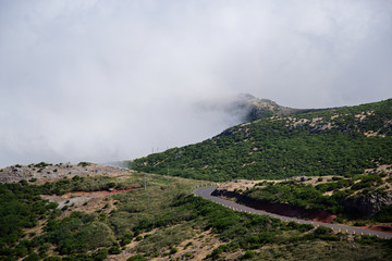 Empty road in the mountains against dense clouds