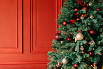 decorated christmas tree near red wall