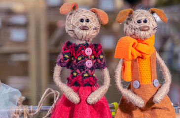 Small figurines of two dogs in bright clothes.