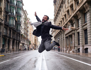 Un chico joven salta en el medio de la calle Via Laietana de Barcelona en un día lluvioso