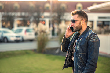 Young man standing and talking over the phone