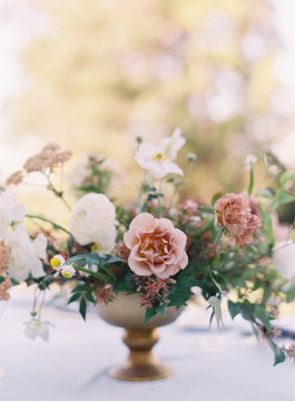 Flowers being used as a centerpiece for an outdoor wedding reception