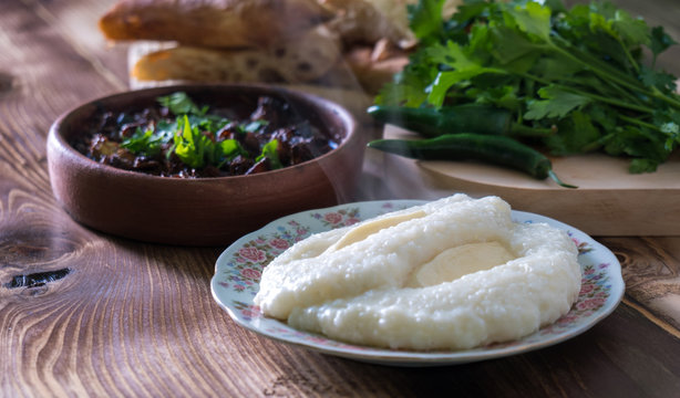 Georgian cuisine - ghomi and kuchmachi with parsley on the wooden table