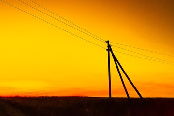silhouette power line on the hill at orange sunset 