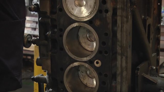 mechanic unscrews the nuts from the engine. Cylinder head. Cylinder head removed from engine for repair. Parts in the engine oil. Disassembled motor vehicle for repair. Parts in engine oil. Car engine