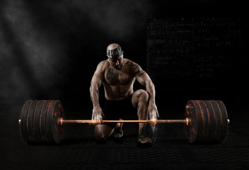 Muscular man workout with barbell at gym