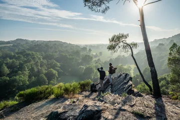 Foto op Plexiglas Hiker couple walk on a mountain trail, overlooking the valley. © jackfrog