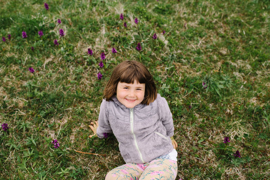 Young girl smiling while sitting on the grass