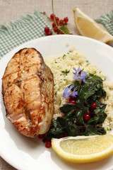 Grilled salmon with couscous, braised chard and red currants.
