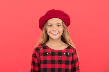 How wear beret like fashion girl. Kid little girl with long hair posing in hat and checkered dress on red background. Fashionable beret hat for female. French style beret hat. Beret style inspiration