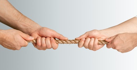 Tug war, two businessman pulling a rope in opposite directions