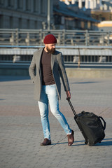 Let travel begin. Traveler with suitcase arrive to airport railway station. Hipster ready enjoy travel. Carry travel bag. Business trip. Man bearded hipster travel with big luggage bag on wheels