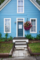 a colorful blue house with hanging flowers and blue door