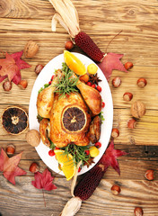 Baked turkey or chicken. The Christmas table is served with a turkey, decorated with fruits, salad and nuts. Fried chicken, table. Christmas dinner
