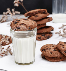 round chocolate cookie is a transparent glass with milk