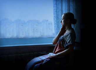 Disabled person in stroller by window
