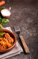 Bigos, a traditional Polish dish with cabbage on brown background