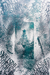Christmas celebration greetings stenciled with confectionary sugar over a rusty blue background