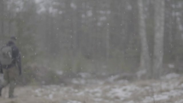 Man in winter tactical gear walking out of focus in slow mo