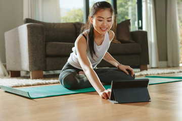 Fitness woman watching training videos on digital tablet