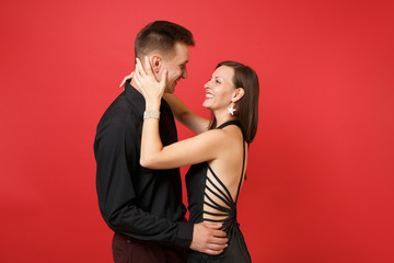 Fashionable young couple in black clothes shirt dress celebrating birthday holiday party isolated on bright red background. St. Valentine International Women Day Happy New Year 2019 concept. Mock up.