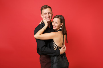 Fashionable young couple in black clothes shirt dress celebrating birthday holiday party isolated on bright red background. St. Valentine International Women Day Happy New Year 2019 concept. Mock up.